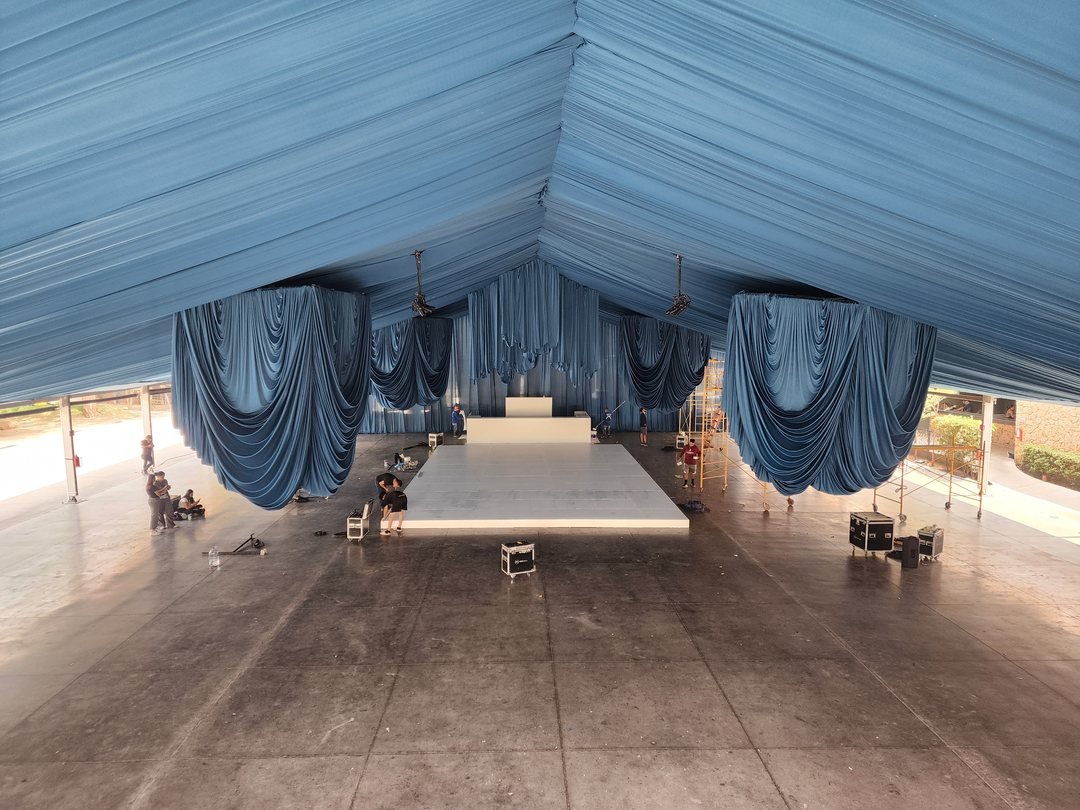 Carpa forrada de tela azul claro con cortinas recogidas y pista blanca