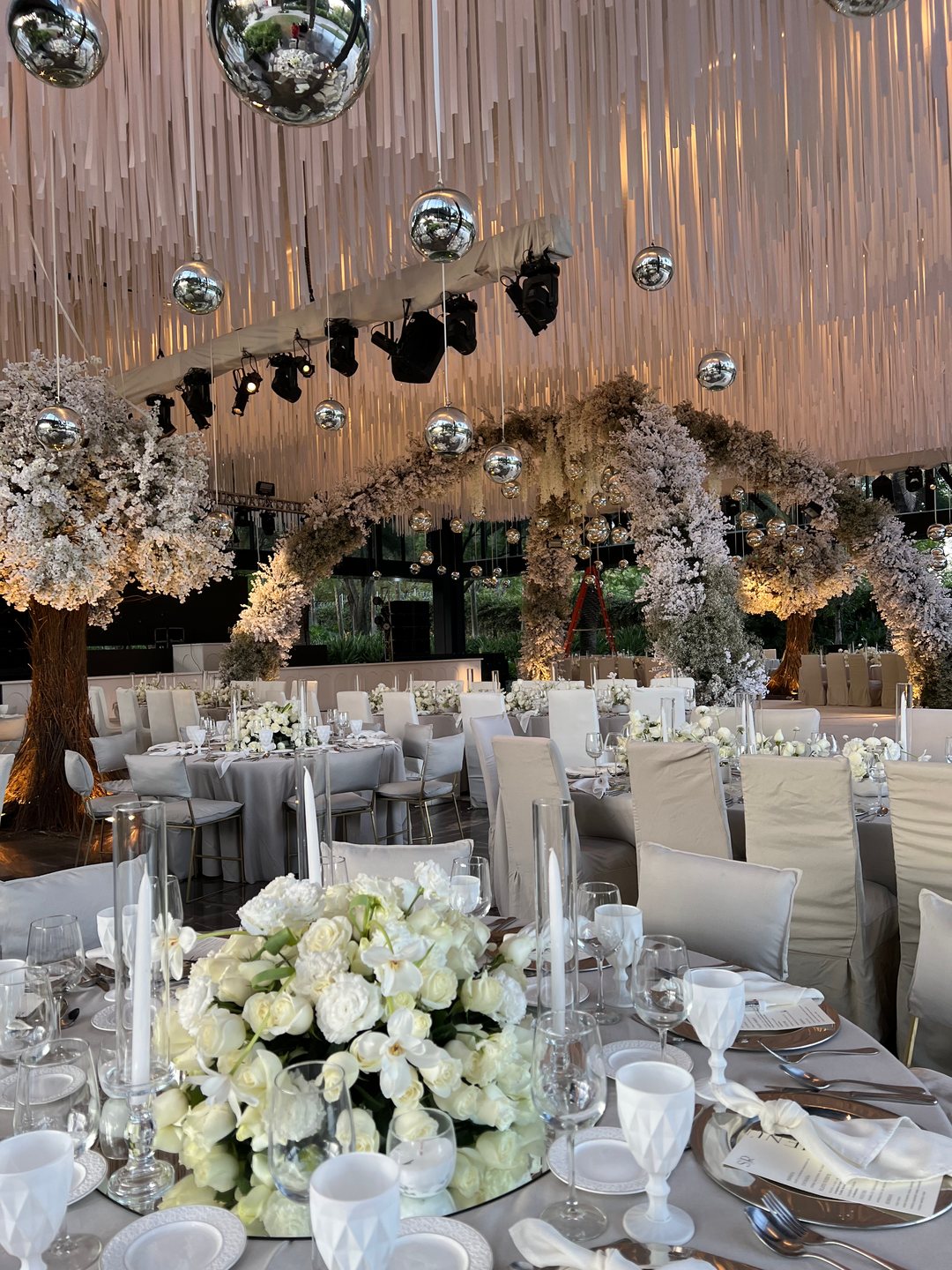 Salón con cielo de tiras de tela blanca, esferas de espejo, árbol de flor y centros de mesa blancos, Tlajomulco