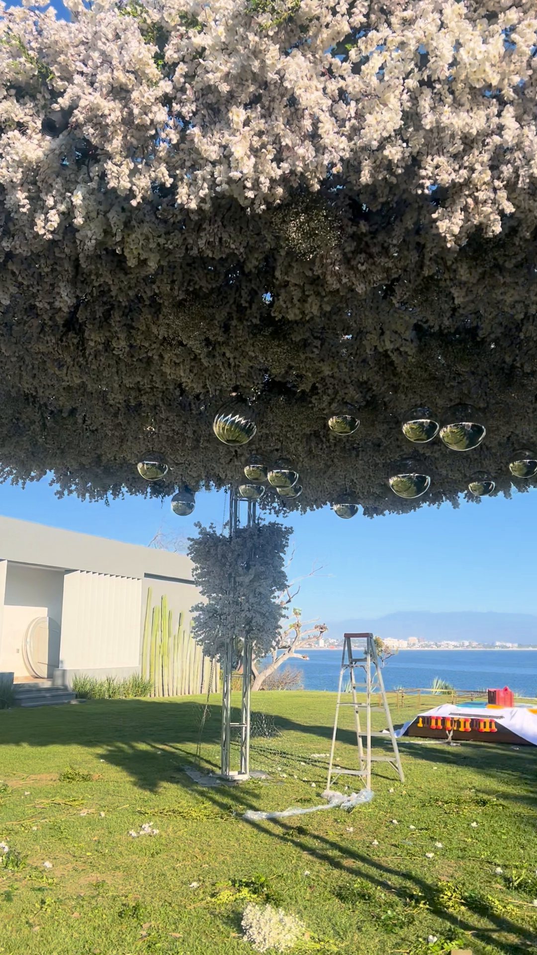 Domo de flor blanca nevada con esferas de espejo en un jardín frente al mar, Riviera Nayarit
