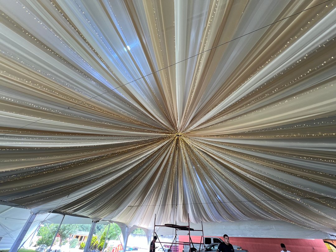Entelado radial en bandas beige y doradas con luces en el techo de una carpa, Puebla