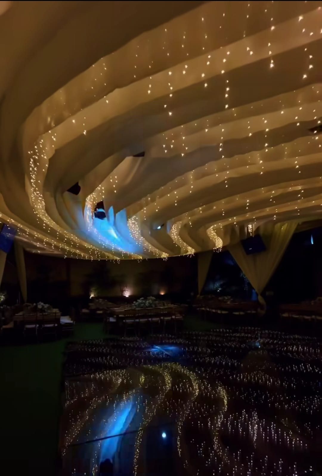 Espiral de tela beige con series de luz sobre el salón, de noche
