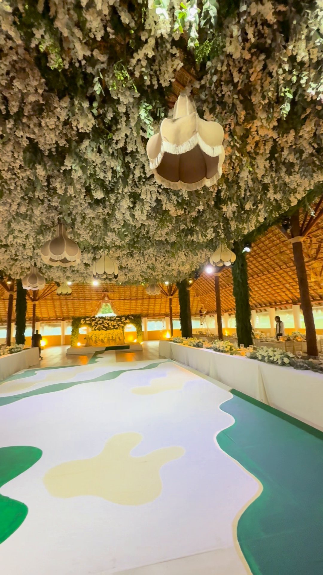 Decoración aérea bajo una palapa: flor blanca y follaje colgando de todo el techo, con candiles de tela, Zapopan