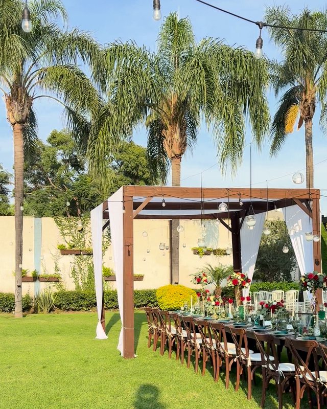 Después: el mismo jardín con pérgolas enteladas y la mesa imperial montada