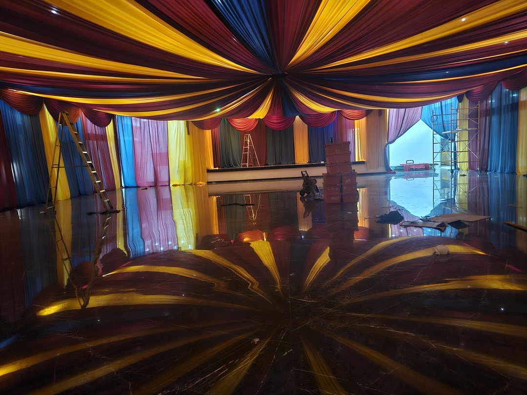 Techo de tela en rojo, amarillo y azul tipo circo, reflejado en la pista