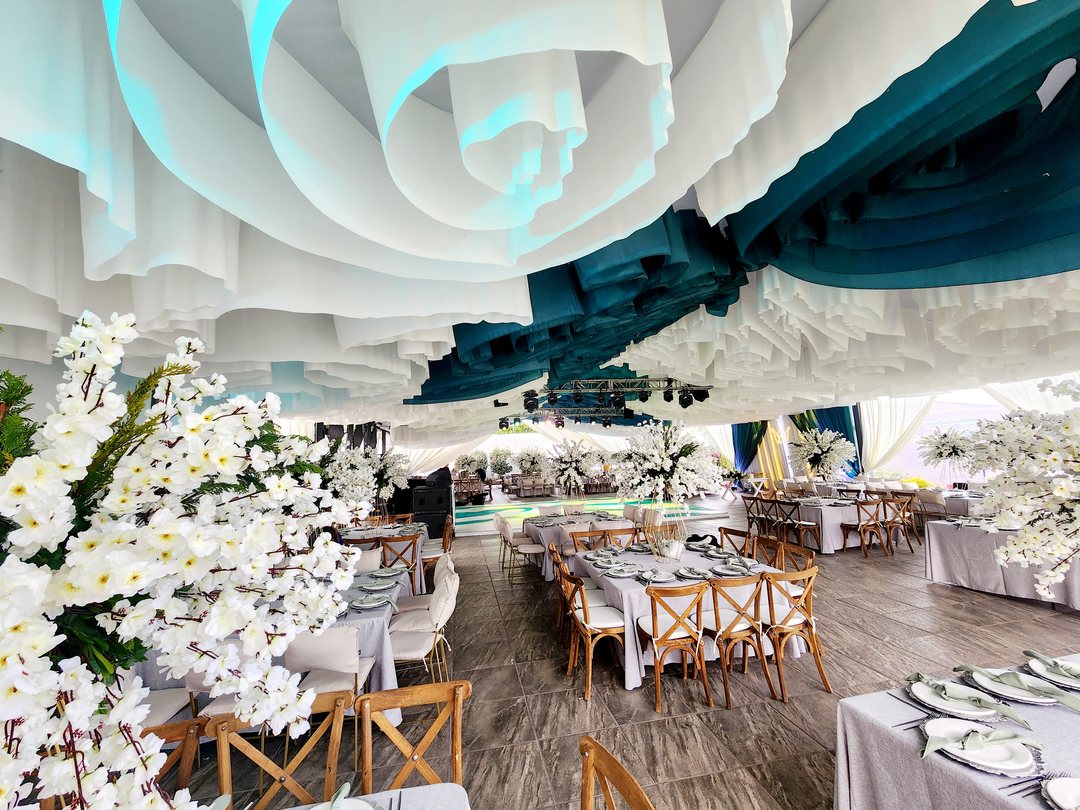 El mismo techo en espiral blanco y turquesa sobre mesas de madera con orquídeas blancas