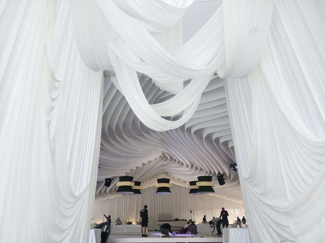 Túnel de drapeado blanco hacia el escenario, durante el montaje