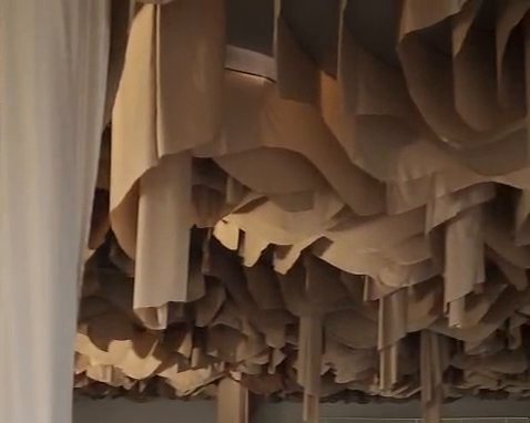 Techo de tela beige en pliegues con tiras largas que bajan como columnas